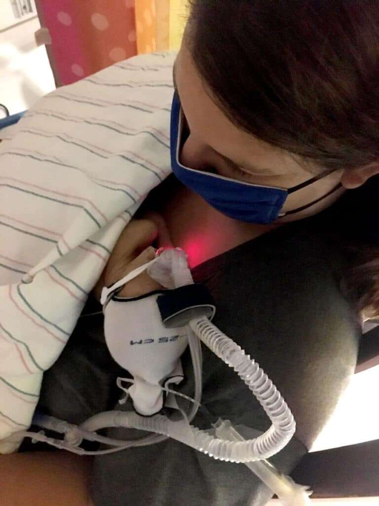 Mom holding premature baby for the first time.