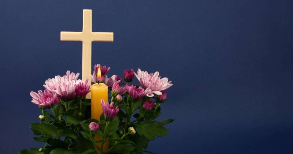 Cross and candle inside ring of flowers to symbolize grief